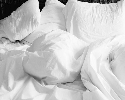 Comfortable bed with soft evening lighting