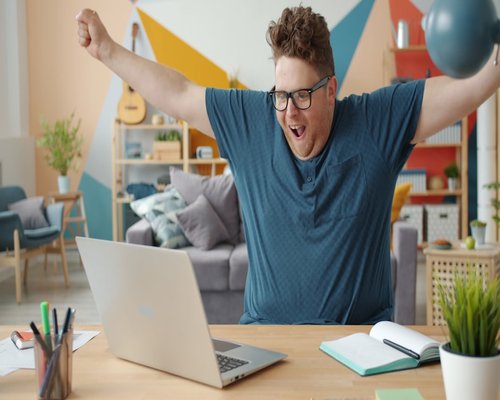 Office worker stretching arms while looking away from laptop